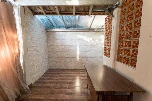 a wooden bench in a room with a brick wall at Casa em Jardim Guaporé - DS1993 in Maringá