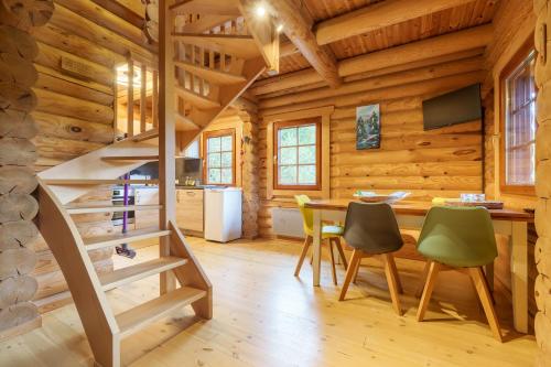 - un escalier dans une cabane en rondins avec une table et des chaises dans l'établissement Chalet des Noisetiers - Magnifique vue montagne, à Cornimont