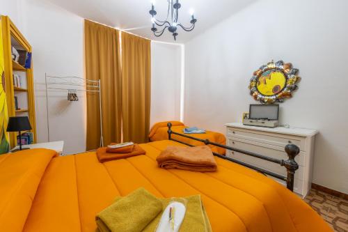 a bedroom with an orange bed with towels on it at Casa Vacanza Dimora Vincenza in Luino