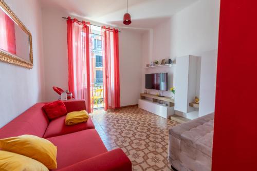 a living room with a red couch and a television at Casa Vacanza Dimora Vincenza in Luino
