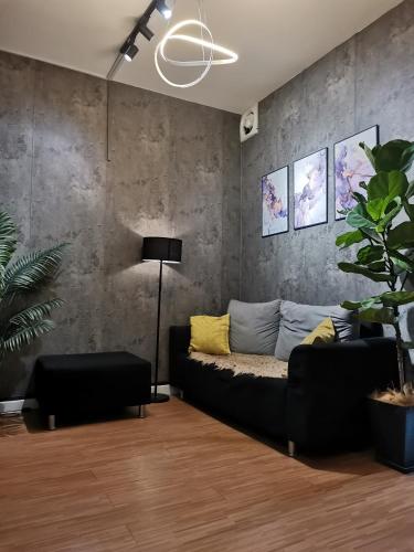 a living room with a couch and a concrete wall at Sabai Sabai Guesthouse in Bayan Lepas in Bayan Lepas