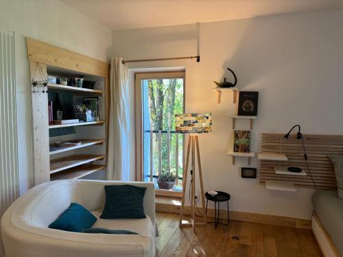 - un salon avec un canapé blanc et une fenêtre dans l'établissement Appartement moderne dans ferme rénovée, à Champagnole