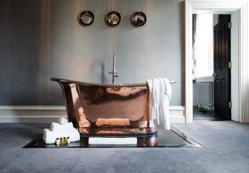 a bathroom with a copper tub in a room at Poets House in Ely