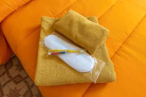a toothbrush and a pencil sitting on a orange pillow at Casa Vacanza Dimora Vincenza in Luino