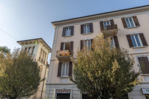 a tall building with trees in front of it at Casa Vacanza Dimora Vincenza in Luino
