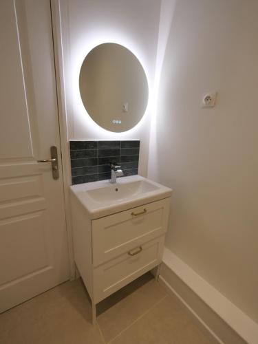a bathroom with a sink and a mirror at D-Day Suites in Carentan
