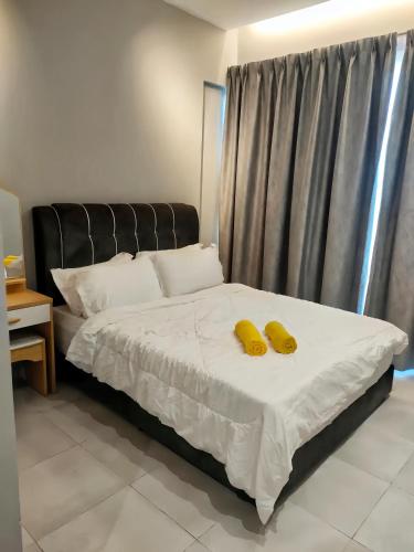 a bedroom with a bed with two yellow bananas on it at Kingfisher Sandakan in Sandakan