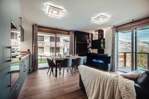 une cuisine et un salon avec une table et des chaises dans l'établissement Apartment Nid des Neiges - Perfect for families, à Combloux