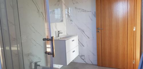 a bathroom with a sink and a marble wall at Quinta da Bornacha - Casa B e Casa C in Vila Nova De Cacela