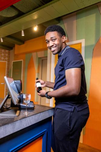 a man standing at a counter with a glass of wine at Tourist Inn Hotel Amsterdam in Amsterdam