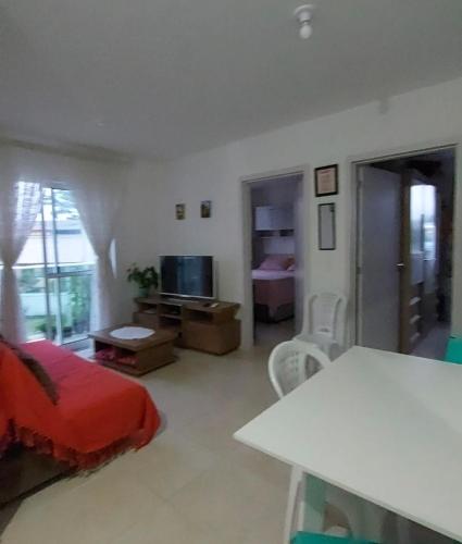 a bedroom with a bed and a table and a television at Praia da Cachoeira in Florianópolis