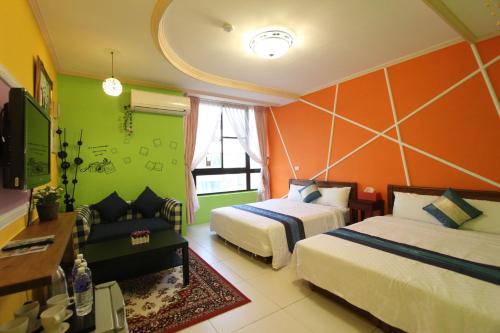 Habitación de hotel con 2 camas y sofá en Kenting Diack Inn, en Hengchun