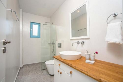 a white bathroom with a sink and a shower at Villa Kalathos Dream White in Kalathos
