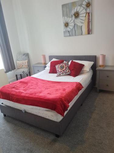 a bed with red pillows on it in a bedroom at Victoria Hotel in Portknockie