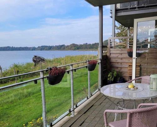 a porch with a table and a view of the water at Hejlsminde ferie- og badeby in Hejls