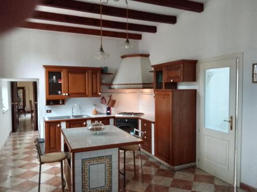 a kitchen with wooden cabinets and a island in it at Villa Gildanna2 in Orio Litta