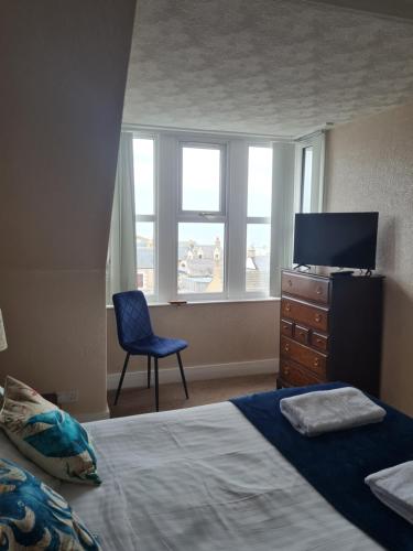 a bedroom with a bed and a television and a chair at Victoria Hotel in Portknockie