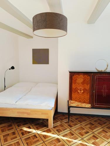 a bedroom with a bed and a dresser at Casa Jenini - Wohnung im Patrizierhaus neben Schloss Leuk in Leuk