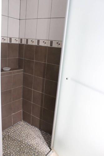 La salle de bains est pourvue d'une douche et de carrelage brun. dans l'établissement Pavillon dans résidence avec piscine au cœur d'Argeles sur mer- 6PM120, à Plage dʼArgelès