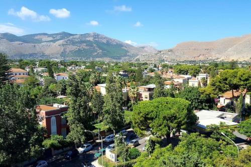 a city with trees and buildings and mountains in the background at Mondello Luxury Apartment on the Beach in Mondello