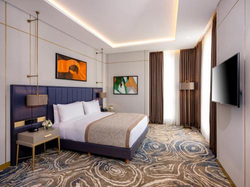 a hotel room with a bed and a flat screen tv at InterContinental Baku by IHG in Baku