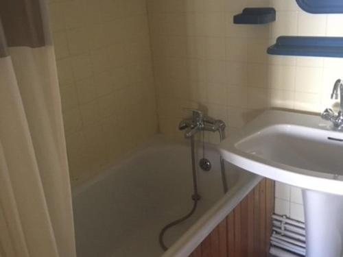 une salle de bain avec une baignoire et un lavabo dans l'établissement Appt ski-in/ski-out avec lit gigogne et casier à skis - FR-1-351-57, à La Plagne