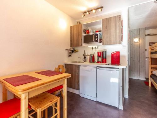 une petite cuisine avec une table en bois, une table et des chaises dans l'établissement Studio rénové à Plagne Centre, accès direct pistes de ski, balcon, parking gratuit - FR-1-351-79, à La Plagne