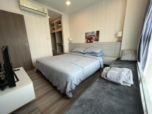a bedroom with a bed and a tv in it at The Prio Condo Chiang Mai in Chiang Mai