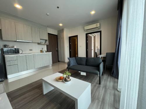 a living room with a couch and a table at The Prio Condo Chiang Mai in Chiang Mai