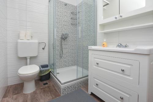 a bathroom with a shower and a toilet and a sink at Relax 1 in Pakoštane