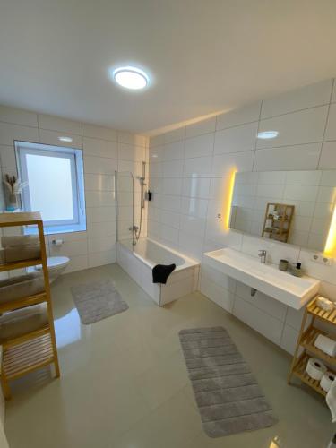 a bathroom with two sinks and a bath tub and a window at SLEEP WELL Apartments DETMOLD - Tempur Beds- NEU - Top Lage - Free parking - WIFI in Detmold