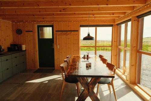 a dining room with a table and chairs and a window at Múlafossur Cottages by famous waterfall in Gásadalur in Gásadalur