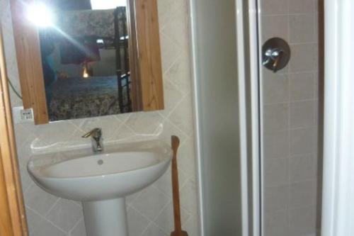 a bathroom with a sink and a mirror and a shower at Chalet Rustico Bertolini per Gruppi! in Vermiglio