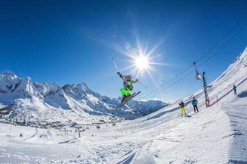 a person jumping in the air on skis in the snow at Chalet Rustico Bertolini per Gruppi! in Vermiglio