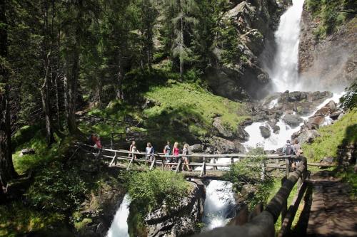 a group of people crossing a bridge over a waterfall at Chalet Rustico Bertolini per Gruppi! in Vermiglio