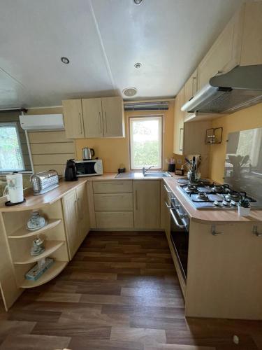 une cuisine avec une cuisinière et un évier dans l'établissement Coquet mobilehome 8 places, à Puget-sur Argens