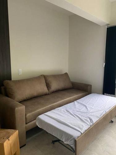 a living room with a couch and a bed at Departamento Pinamar centro Jupiter in Pinamar