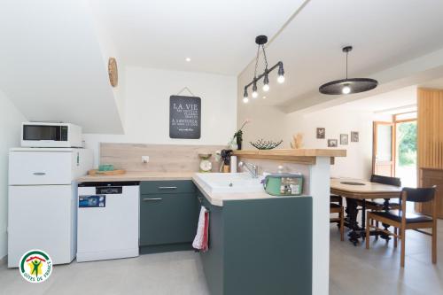 a kitchen with blue and white appliances and a table at Gîte des Mouliniers in Saint-Siméon-de-Bressieux