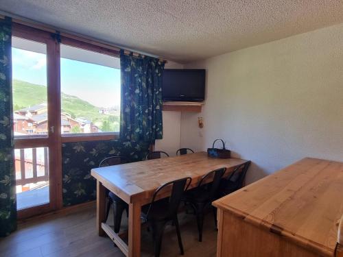 une salle à manger avec une table et une grande fenêtre dans l'établissement Appartement au pied des pistes, 2 chambres, proche commerces, à Plagne Village - FR-1-351-181, à La Plagne Tarentaise