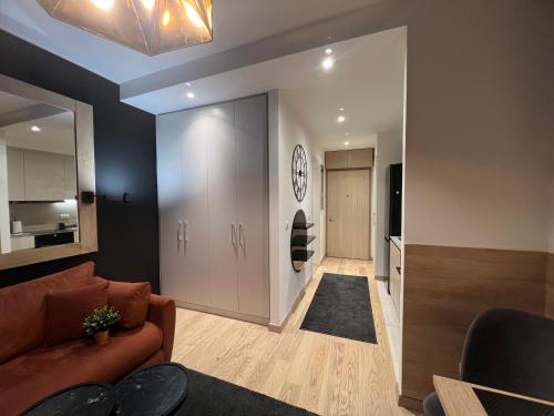 a living room with a couch and a clock on the wall at Belgrade Waterfront Lux Studio Apartment in Belgrade