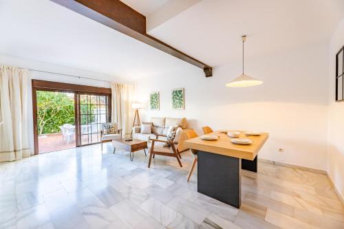 een woonkamer met een tafel en een bank bij Casa Jardines del Sol 4 in Marbella