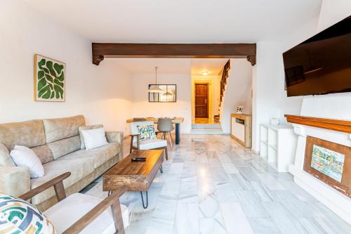 een woonkamer met een bank en een open haard bij Casa Jardines del Sol 4 in Marbella