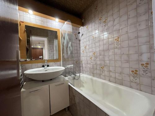 une salle de bain avec un lavabo et une baignoire dans l'établissement Appartement confort 3 pièces cabine skis aux pieds, balcon, 6 personnes - Auris en Oisans - FR-1-297-27, à Auris