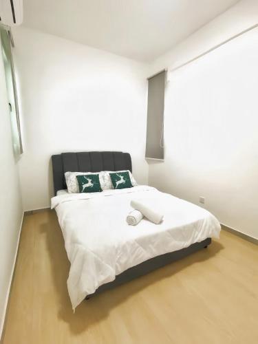a bedroom with a large bed with white sheets at Kingfisher Sandakan in Sandakan