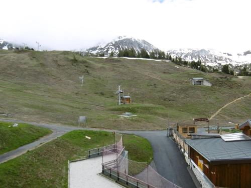 une route sinueuse sur une colline avec une montagne dans l'établissement Studio lumineux à Plagne Villages, balcon, proche pistes et commerces - FR-1-351-64, à La Plagne