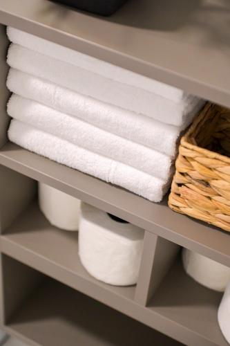 a shelf with rolls of toilet paper and towels at Luxury living by Dazzie in Skopje