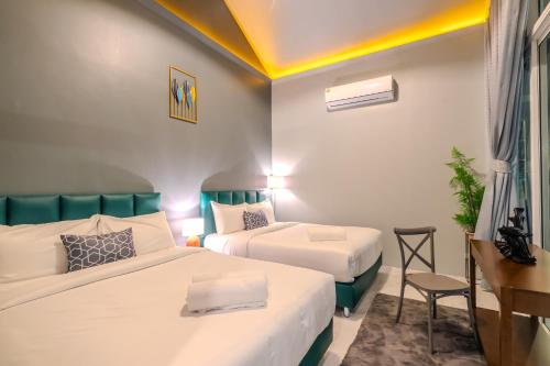 a hotel room with two beds and a desk at BellaBella Private Pool Villa Hua Hin in Hua Hin