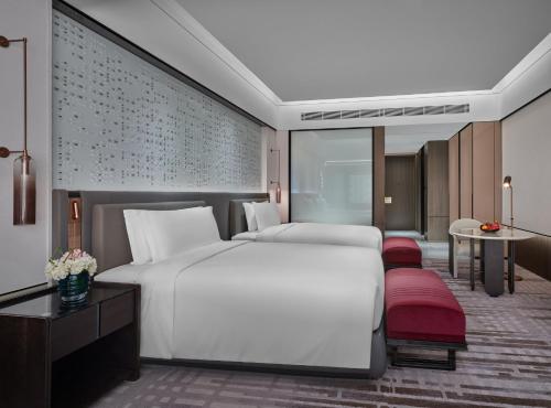 a bedroom with a large white bed and a desk at InterContinental Shenzhen WECC by IHG in Shenzhen
