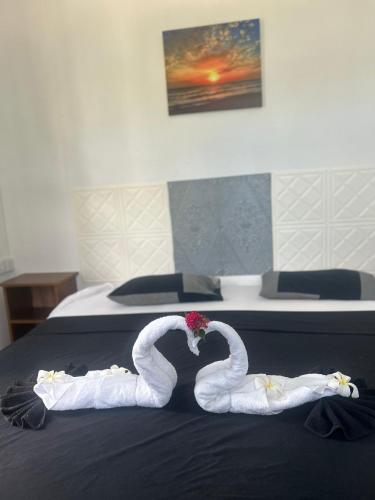 two swans made out of towels on a bed at Skipper Dan Bungalow in La Gaulette
