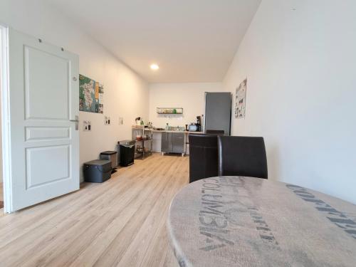 une pièce avec une table, des chaises et une porte dans l'établissement La Chambre Bleue - Chambre avec salle de bain, à Argenton-sur-Creuse